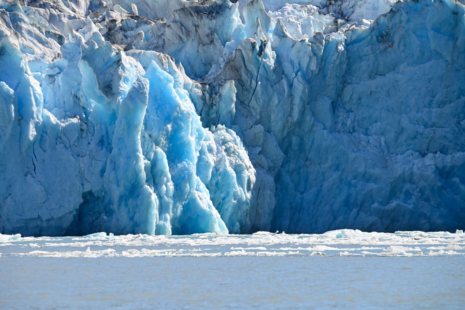 Tidewater glacier calving ice into the water in Alaska